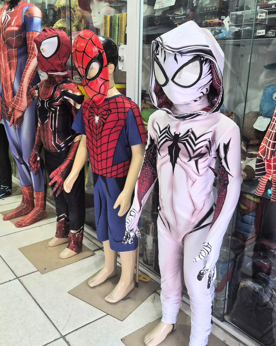 Fantasias infantis de Homem-Aranha e Venom expostas em manequins na loja